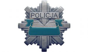 Zdjęcie kolorowe. Odznaka policyjna z napisem policja.