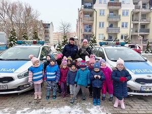 Zdjęcie kolorowe. Grupa dzieci zwiedza KPP w Szczecinku