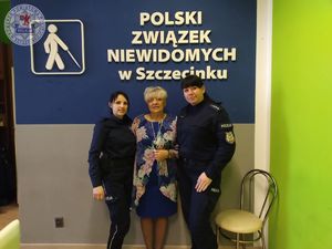 Policjantki podczas spotkania. W tle napis Polski Związek Niewidomych w Szczecinku